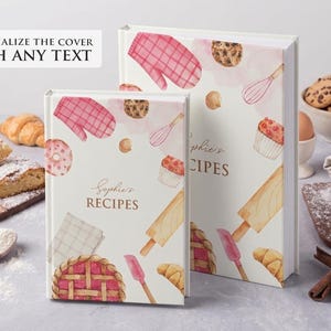 Puede incluir: Dos libros de recetas con ilustraciones en acuarela de utensilios de cocina y pasteles. Los libros son blancos con detalles en rosa y beige, y el texto "Sophie's RECIPES" aparece en la portada. También se ve el texto "Personaliza la portada con cualquier texto".