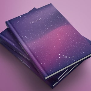 Op de afbeelding: Een stapel van drie notitieboekjes met een galaxy-print op de omslag. Het bovenste notitieboekje heeft de naam "SOPHIE" op de omslag gedrukt. De twee onderste notitieboekjes hebben de tekst "YOUR TEXT HERE" op de omslag gedrukt.