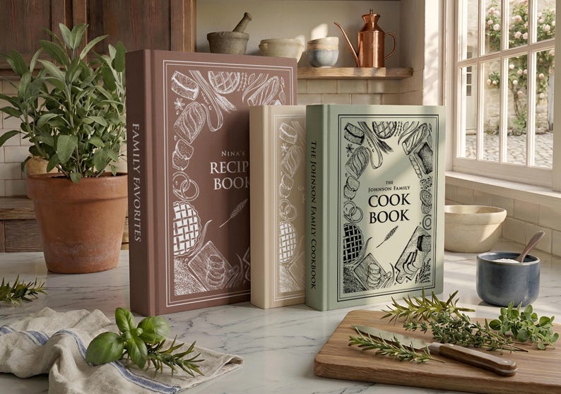 May include: Three hardcover books standing upright, featuring a brown book titled Nina's Recipe Book, a beige book, and a light green book titled The Johnson Family Cook Book. Each cover displays white line art illustrations of various food items.