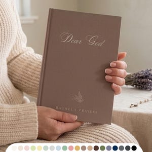 Peut inclure: Un journal à couverture rigide de couleur taupe présentant le texte en relief "Dear God" en écriture cursive en haut, une petite icône d'oiseau au centre et le texte "RACHEL'S PRAYERS" dans une police sans empattement en bas de la couverture.