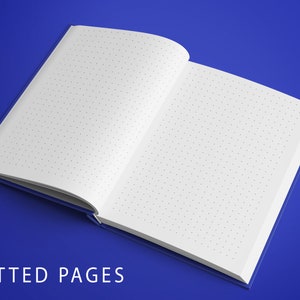 Op de afbeelding: Open notitieboek met witte gestippelde pagina's op een blauwe achtergrond. De tekst "DOTTED PAGES" is onder het notitieboek gedrukt.
