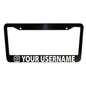 Op de afbeelding: Zwarte kentekenplaathouder met een wit Instagram-logo en de tekst "YOUR USERNAME".