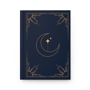 Peut inclure: Une couverture de carnet bleu foncé avec un motif de croissant de lune et d'étoiles dorées. La couverture a une bordure géométrique avec des rayons de soleil en haut et en bas.