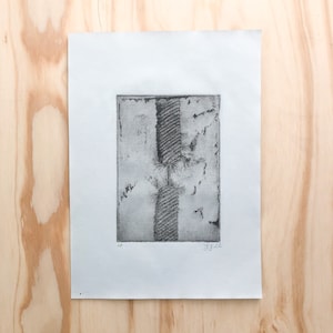 May include: A black and white print of a rope with a textured surface. The print is signed "AP" and "J.J.L." in the bottom corners.