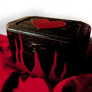 May include: A black wooden box with a red heart on the lid. The box has red dripping paint on the sides.