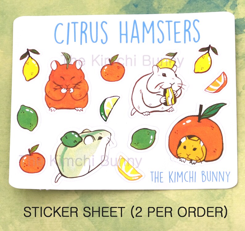 May include: Sticker sheet with a citrus theme featuring hamsters. The sheet includes images of hamsters eating citrus fruits, such as oranges, lemons, and limes. The text "CITRUS HAMSTERS" and "THE KIMCHI BUNNY" are printed on the sheet. The sheet also includes the text "STICKER SHEET (2 PER ORDER)".