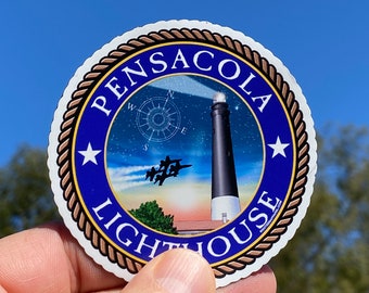 May include: A blue and gold round sticker with the text "PENSACOLA LIGHTHOUSE" and a depiction of a lighthouse with a star-filled sky and a compass rose.