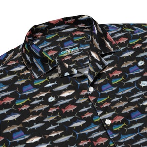 May include: A black button-up shirt with a colorful fish print. The shirt has a collar and a button closure. The brand name "COYOTEES" is visible on the collar.