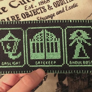 Peut inclure: Un patch brodé noir et vert avec trois images et du texte. Les images sont un réverbère, une porte et un spectre. Le texte dit "Gaslight", "Gatekeep" et "Ghoulboss".