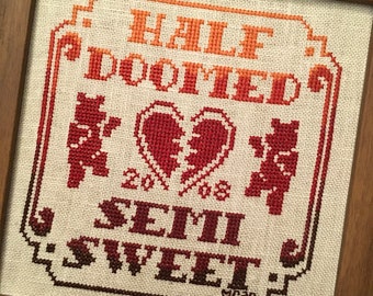 Könnte beinhalten: Kreuzstich-Stickerei mit einem Farbverlauf von Rot, Orange und Gelb. Das Design zeigt zwei Bären, ein gebrochenes Herz und den Text "Half Doomed, Semi Sweet".