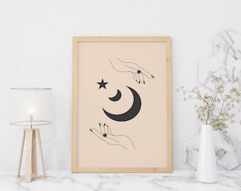 以下が含まれることがあります： 三日月と星に向かって手を伸ばした2本の腕を描いた、ミニマルなデザインの額装されたプリント。背景は薄いベージュ色です。