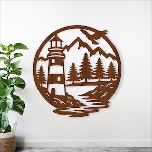 Könnte beinhalten: Ein kreisförmiges Wandkunstwerk aus braunem Holz mit einem Leuchtturm, Bergen, Bäumen und einem fliegenden Vogel. Das Design ist ausgeschnitten, wodurch ein Silhouetteffekt entsteht. Der Leuchtturm hat detaillierte Fenster und ein Licht an der Spitze.