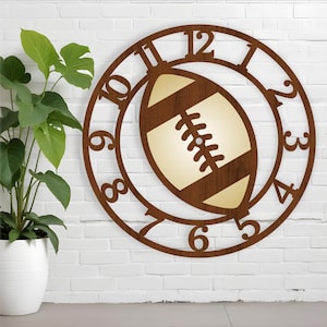 Könnte beinhalten: Eine braune Holzuhr mit einem Fußball-Design. Das Zifferblatt der Uhr hat römische Ziffern und einen Fußball in der Mitte.
