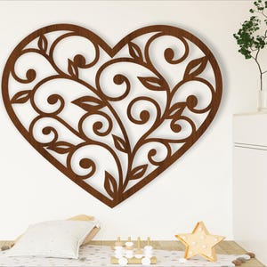 May include: A brown wooden heart-shaped wall decor with a decorative floral pattern.