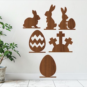 May include: Wooden Easter decorations with bunny silhouettes and egg shapes. The decorations are brown and have a wood grain texture.