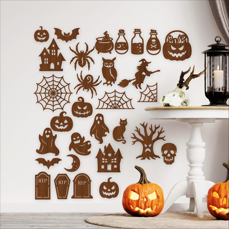 Puede incluir: Colecci&oacute;n de decoraciones de Halloween de madera marr&oacute;n, que incluyen murci&eacute;lagos, ara&ntilde;as, calabazas, fantasmas y una casa embrujada. Las decoraciones est&aacute;n en una pared blanca, con dos calabazas talladas y una mesa con una vela.
