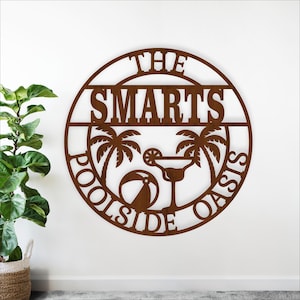 Könnte beinhalten: Braunes, kreisförmiges Metallschild mit den ausgeschnittenen Worten "THE SMARTS POOLSIDE OASIS". Das Design umfasst Palmen, einen Cocktail und einen Strandball. Das Schild ist ein dekorativer Artikel.