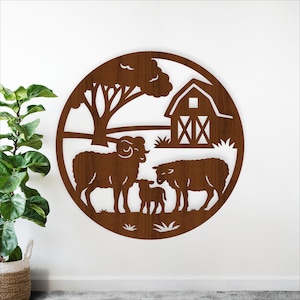 May include: A round, wooden wall art piece featuring a farm scene. The design includes a ram, two sheep, a lamb, a barn, and a tree. The artwork is cut from wood and has a natural brown finish. The overall theme is rustic and pastoral.