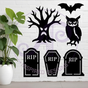 Puede incluir: Recortes negros con tem&aacute;tica de Halloween que incluyen un murci&eacute;lago, un b&uacute;ho, un &aacute;rbol con una cara y tres l&aacute;pidas con el texto "RIP". Los recortes se muestran contra una pared de ladrillos blancos, con una planta en maceta en primer plano.