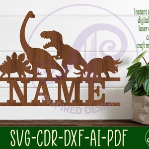May include: A digital cut file design featuring a silhouette of five dinosaurs with the word "NAME" underneath. The dinosaurs include a stegosaurus, a brachiosaurus, a tyrannosaurus rex, and two triceratops. The design is suitable for laser cutting and crafting.