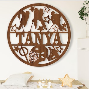 May include: A brown wooden circle with a hockey theme. The circle has a cutout of the name "TANYA" and hockey players, a hockey stick, a puck, and stars.