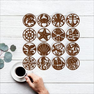 May include: A collection of brown wooden coasters with nautical and marine life designs. Each coaster features a different image, including a dolphin, crab, octopus, anchor, ship's wheel, starfish, fish, lighthouse, whale tail, seashell, turtle, palm trees, compass, seahorse, sailboat, and jellyfish.
