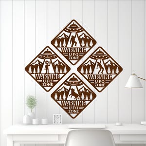 May include: Four brown diamond-shaped wall art pieces with a UFO theme. Each piece features a UFO, mountains, trees, and the text "WARNING UFO ZONE." The designs depict an alien, Bigfoot, and a horse.