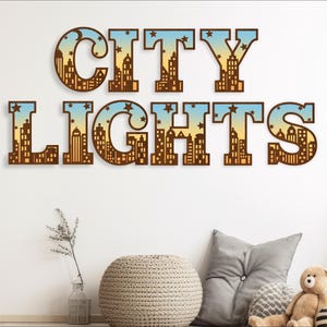 Op de afbeelding: Bruine houten letters die "CITY LIGHTS" spellen met een stadsbeeldontwerp in elke letter. De letters bevinden zich op een witte muur met een lichtbruine bank en een kleine potplant op de voorgrond.