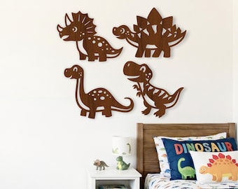 May include: Four dark brown wooden dinosaur wall cutouts featuring a triceratops, a stegosaurus, a long-necked sauropod, and a theropod. These flat, silhouette-style wall decorations are arranged in a grid pattern on a plain white wall.