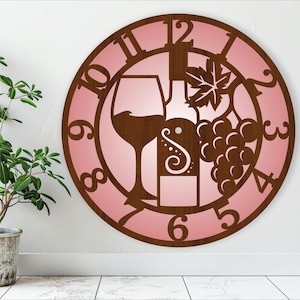Puede incluir: Un reloj de pared de madera rosa con un diseño de copa de vino, botella y uvas. La esfera del reloj tiene números romanos y un contorno marrón.