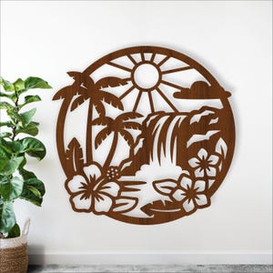 Könnte beinhalten: Ein braunes Wandkunstwerk aus Holz mit einer tropischen Szene. Das Design umfasst Palmen, einen Wasserfall, Hibiskusblüten und eine Sonne. Das Kunstwerk ist kreisförmig und aus Holz geschnitten, wodurch ein geschichteter Effekt entsteht.