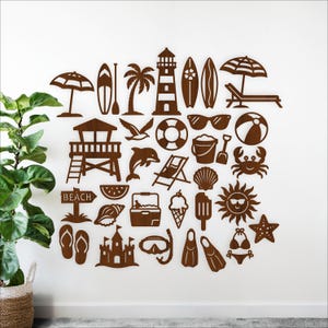Può includere: Una collezione di ritagli di legno marrone a tema spiaggia, tra cui una torre di salvataggio, una tavola da surf, occhiali da sole e un cartello con la scritta "BEACH". Altri ritagli includono un delfino, gelato e un sole.