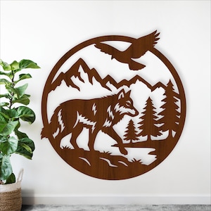 May include: A brown metal wall art piece featuring a wolf walking in a forest scene. The design includes mountains, pine trees, and a flying bird, all within a circular frame. The artwork is mounted on a white wall.