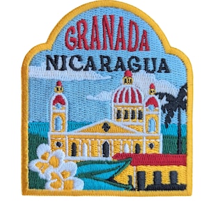 Könnte beinhalten: Ein gestickter Aufnäher mit gelbem Rand, der ein gelbes Gebäude mit roten und weißen Akzenten zeigt. Das Gebäude ist mit "Granada Nicaragua" in roten und schwarzen Buchstaben beschriftet. Der Aufnäher zeigt einen blauen Himmel mit weißen Wolken und grünem Laub.