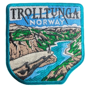 May include: Embroidered patch featuring a scenic view of Trolltunga, Norway. The patch depicts a person standing on a cliff overlooking a turquoise river and mountainous landscape. The text "TROLLTUNGA NORWAY" is embroidered at the top, with a teal border.