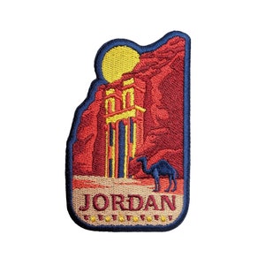 Op de afbeelding: Een geborduurde patch met een afbeelding van een gebouw in een woestijnlandschap. De tekst "JORDAN" is in geel geborduurd op de patch. De patch is blauw en rood.