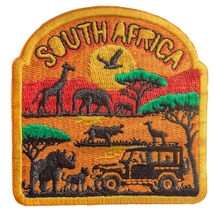 Può includere: Toppa ricamata raffigurante una scena di safari sudafricano. La toppa include il testo "SOUTH AFRICA" in oro, con immagini di giraffe, elefanti, una jeep e altri animali selvatici su uno sfondo di tramonto. La toppa ha un bordo giallo.