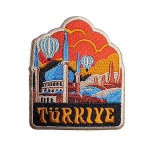 May include: Embroidered patch with a colorful illustration of a mosque and hot air balloons against a red and orange sunset. The text "TÜRKIYE" is written in yellow letters on a black background.