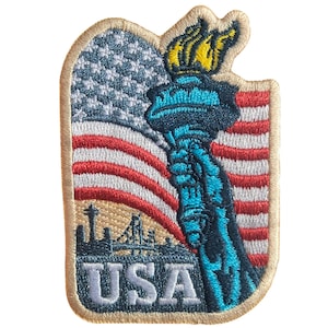 May include: Embroidered patch depicting the Statue of Liberty and an American flag. The patch is rectangular with rounded corners and the word "USA" at the bottom. The design is in red, white, blue, and gold.