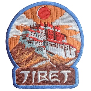 Peut inclure: Écusson brodé représentant un palais tibétain au coucher du soleil. Le design comprend le mot "TIBET" en lettres majuscules blanches sur une base rectangulaire bleue. L'écusson a une bordure bleue.