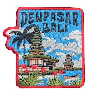 May include: Embroidered patch featuring a Bali landscape with the text "DENPASAR BALI". The design includes a temple, palm tree, flowers, and a boat, set against a blue sky with clouds. The patch has a red border.