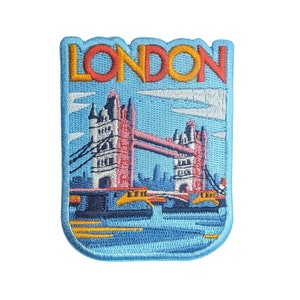 Peut inclure: Un patch brodé bleu et blanc avec le mot "LONDON" en lettres jaunes et rouges. Le patch représente le Tower Bridge de Londres, en Angleterre.