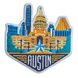 May include: Embroidered patch featuring the Austin, Texas skyline. The patch showcases the Texas State Capitol building, skyscrapers, and a star. The word "AUSTIN" is embroidered in white. The patch has a blue, gold, and teal color scheme.