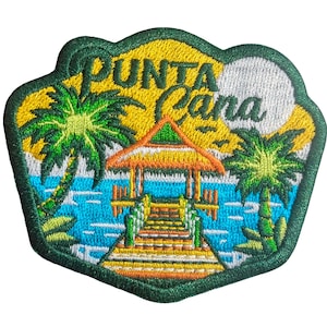 Puede incluir: Parche bordado con una escena tropical con las palabras "PUNTA Cana". El diseño incluye palmeras, un muelle y un mirador sobre agua turquesa, sobre un cielo amarillo y blanco, todo enmarcado por un borde verde.