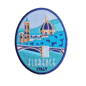 Könnte beinhalten: Gestickter Aufnäher mit einem blauen, weißen und goldenen Bild eines Gebäudes in Florenz, Italien. Der Text "FLORENCE ITALY" ist in Weiß auf blauem Hintergrund gestickt.
