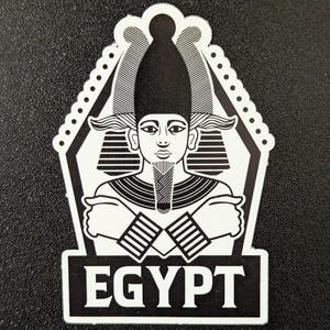 May include: Black and white illustration of an Egyptian pharaoh with a headdress and crossed arms. The image is in a hexagon shape with the word "EGYPT" printed below.