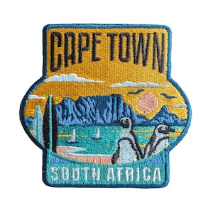 Peut inclure: Patch brodé avec un motif bleu, jaune et blanc. Il présente le texte "CAPE TOWN" et "SOUTH AFRICA" avec une chaîne de montagnes, un coucher de soleil et deux pingouins.