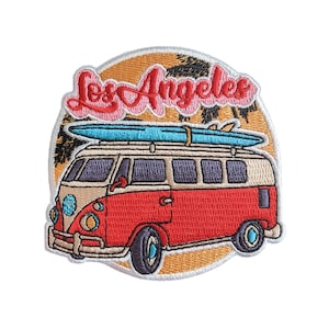 Może przedstawiać: Czerwono-biały, zabytkowy van z deską surfingową na dachu, jadący przez zachód słońca z palmami i napisem "Los Angeles" w różowych literach.