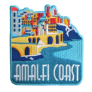 Könnte beinhalten: Gestickter Aufnäher mit einer farbenfrohen Darstellung der Amalfiküste. Das Design zeigt Gebäude in Gelb-, Orange- und Blautönen, eine gelbe Brücke und den Text "AMALFI COAST" in Weiß.