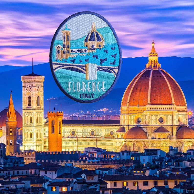 Puede incluir: Un parche bordado que representa Florencia, Italia, con el texto "FLORENCE ITALY". El parche muestra el Duomo y el Campanile sobre un fondo azul y turquesa. La imagen est&aacute; situada sobre un cielo p&uacute;rpura y azul, evocando el viaje.